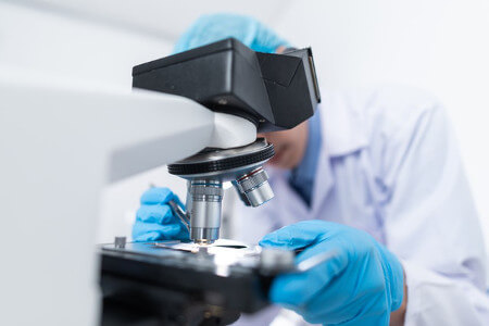 Scientist Using Microscope to Study Medicine